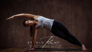 A woman practicing yoga in a bright studio, showing flexibility and balance benefits from regular yoga practice